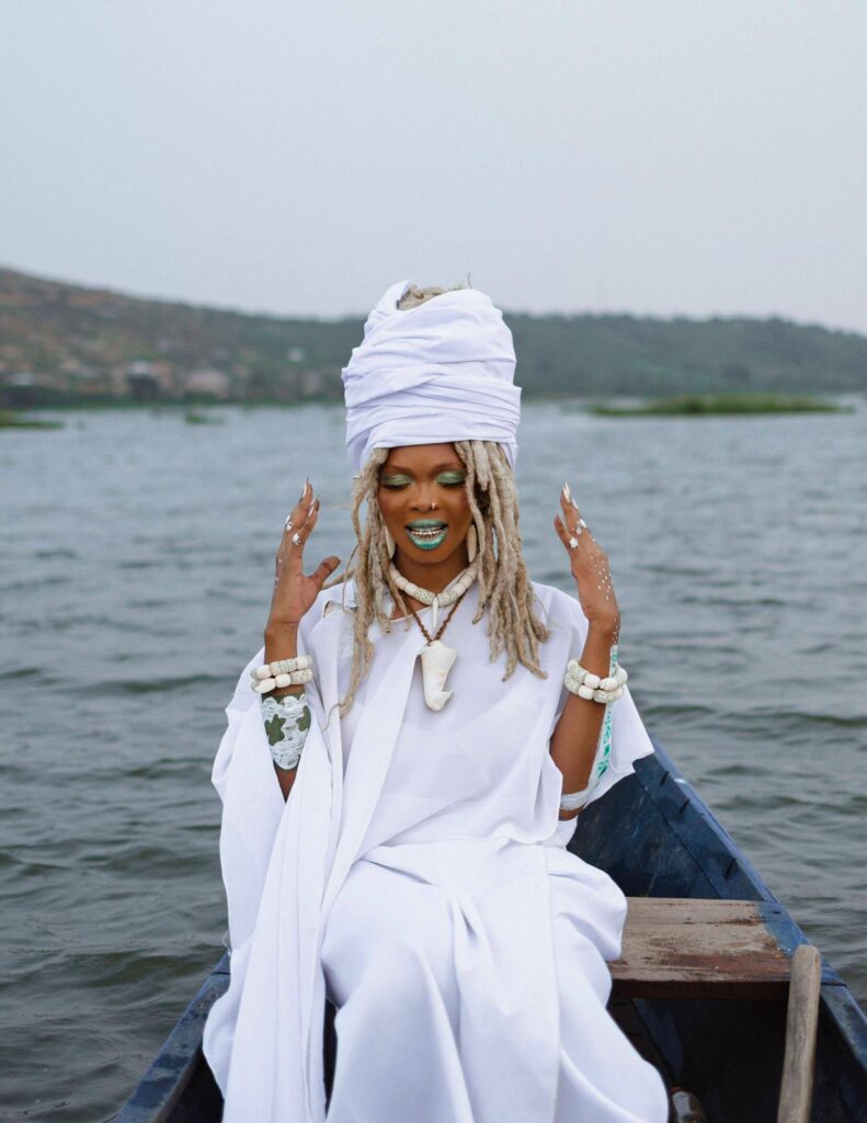 Scène cinématographique du clip Modzi d'Enam montrant une cérémonie spirituelle au bord de l'eau.